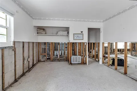 a view of a house with potted plants and a large tree