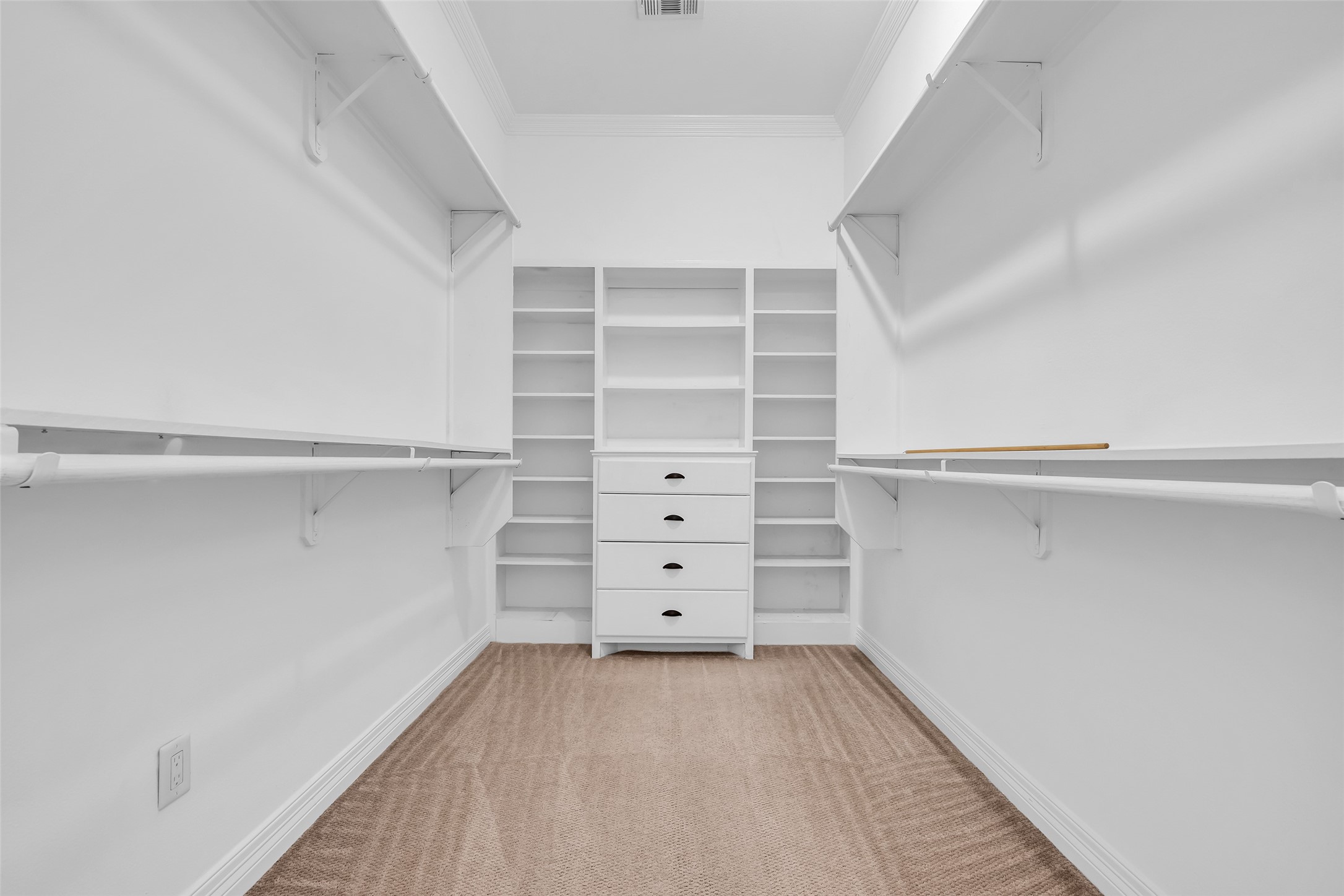 1423 Colorado Street Houston, TX 77007 - Photo 14 of 28 The primary bedroom includes a walk-in closet with built-in shelves and hanging racks, offering organized storage for clothing and accessories.