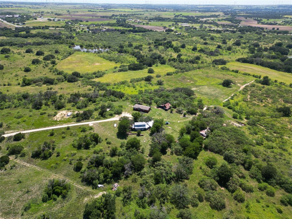 an aerial view of residential houses with outdoor space and trees