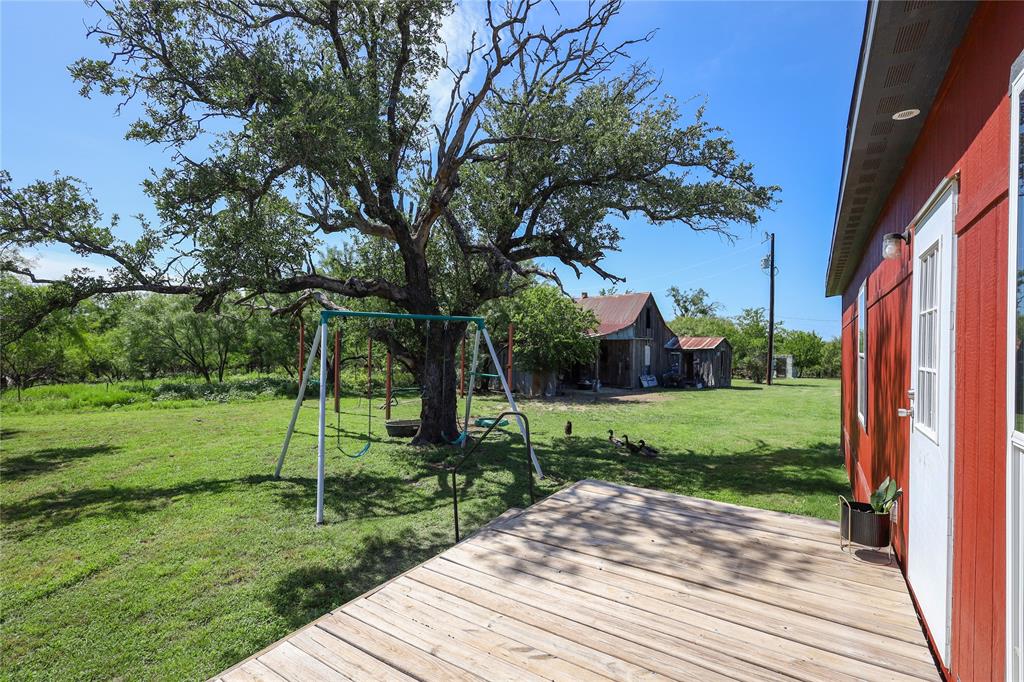55 County Road West Comanche, TX 76442 - Photo 11 of 37 Wooden terrace with a playground and a lawn