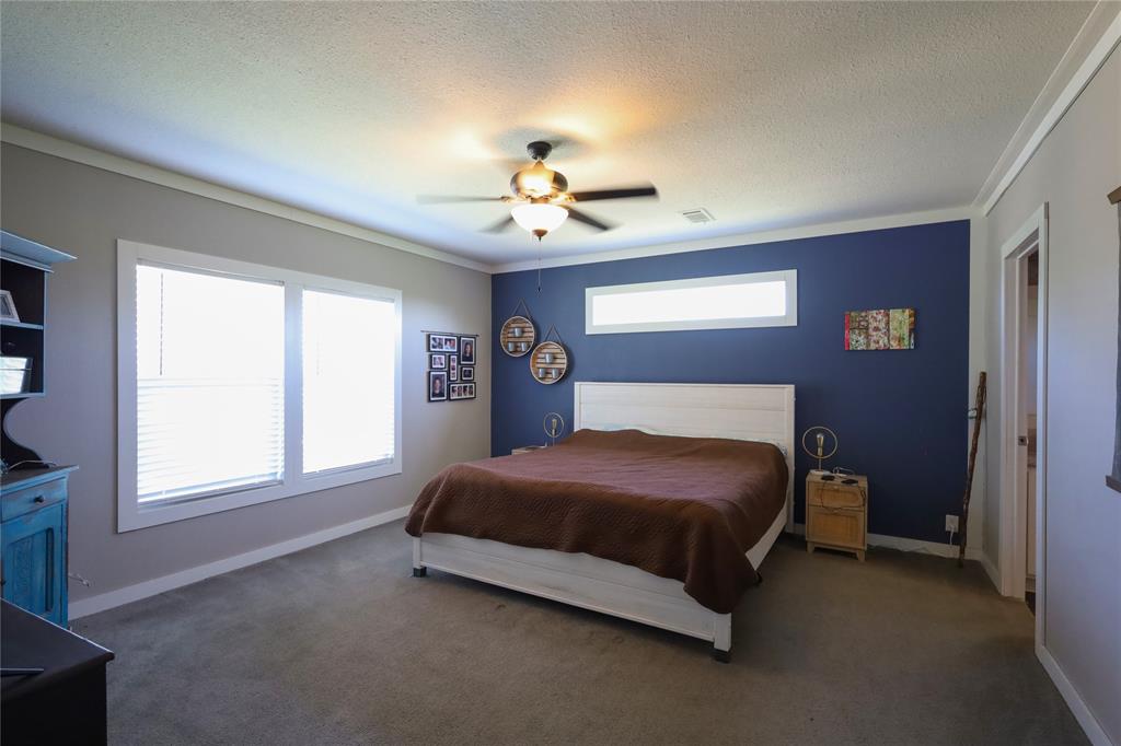 55 County Road West Comanche, TX 76442 - Photo 19 of 38 a bedroom with a bed chandelier and a window