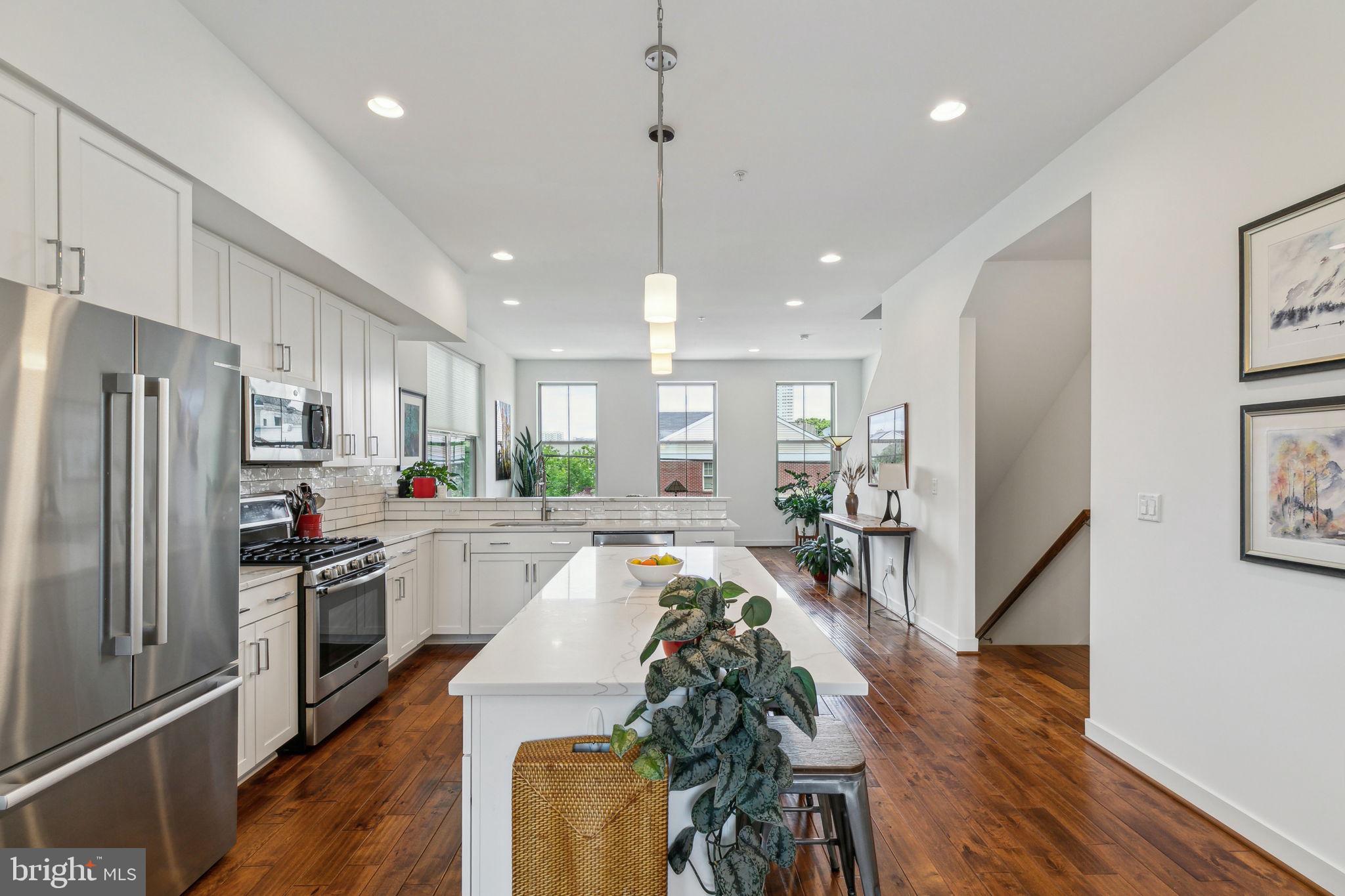 410 Reed Street Philadelphia, PA 19147 - Photo 2 of 39 a large kitchen with kitchen island a large counter top space a sink stainless steel appliances and cabinets