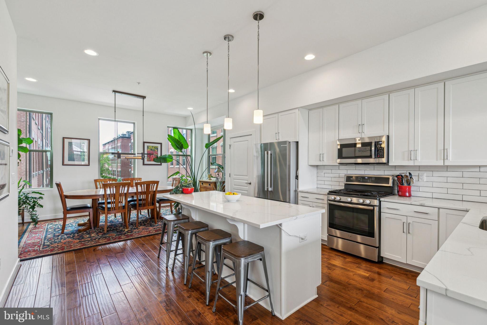410 Reed Street Philadelphia, PA 19147 - Photo 5 of 39 a kitchen with stainless steel appliances a dining table chairs stove refrigerator and microwave