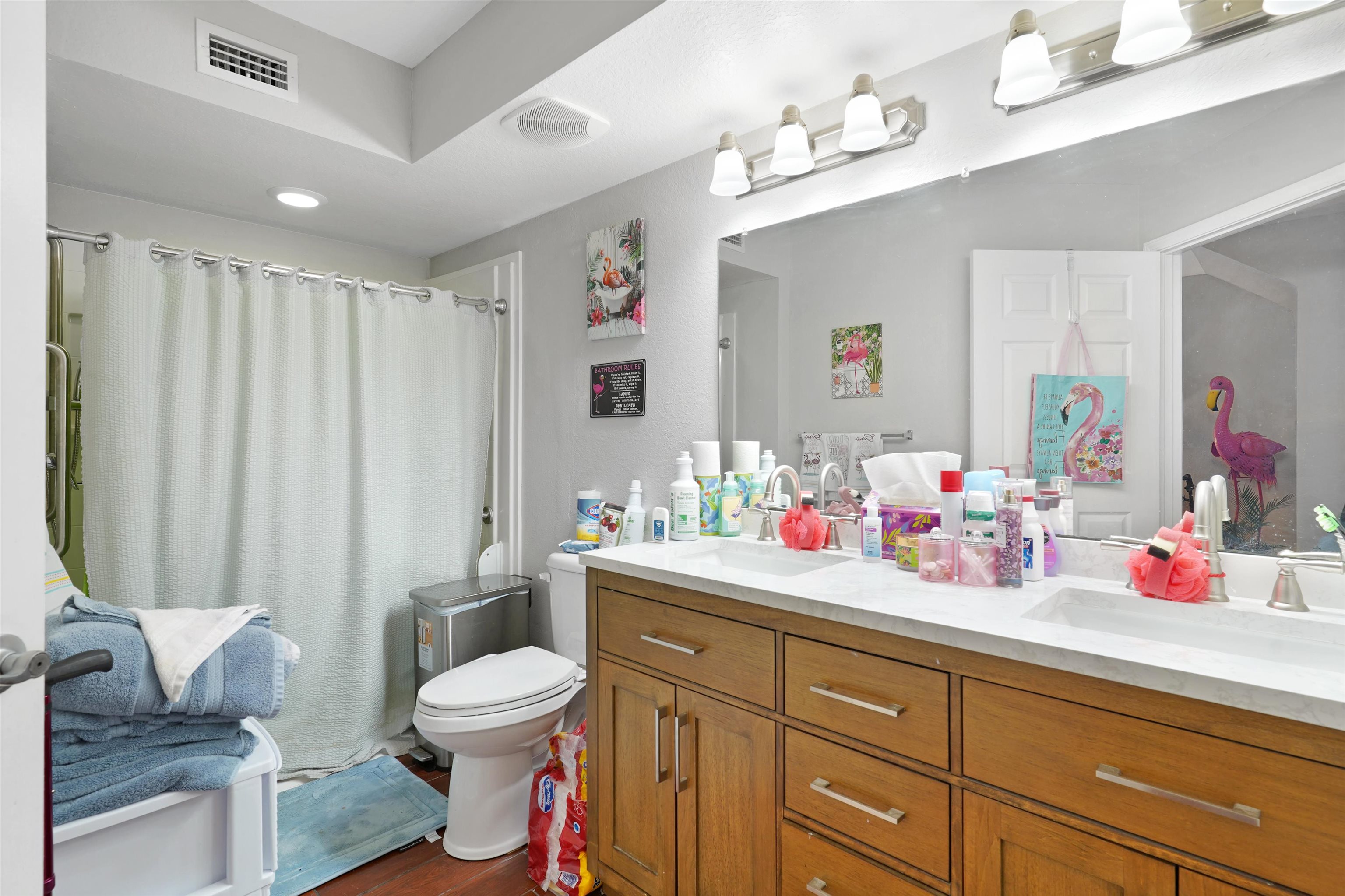 10075 Gate Parkway, Unit 203 Jacksonville, FL 32246 - Photo 12 of 34 Bathroom with double vanity, a shower with shower curtain, and dark wood-style flooring