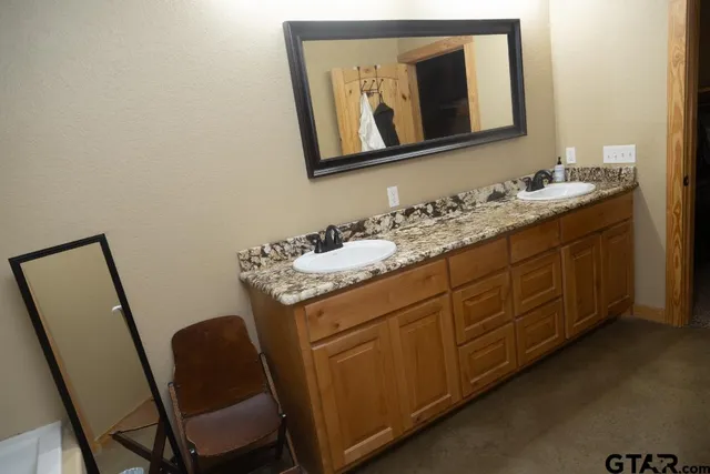 a en suite bathroom with a granite countertop sink and a mirror
