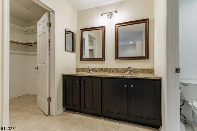 a bathroom with a granite countertop sink vanity and mirror