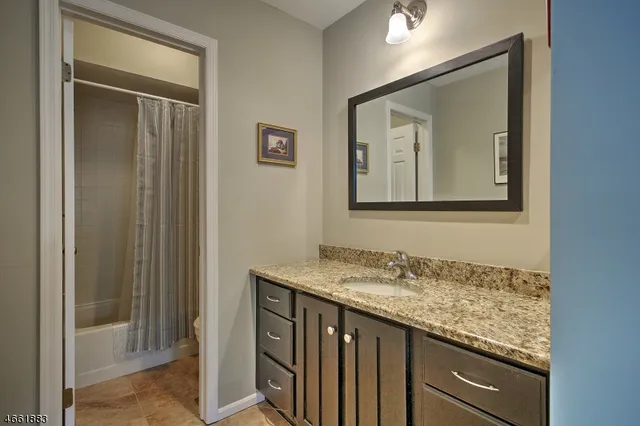 a bathroom with a granite countertop sink mirror and vanity
