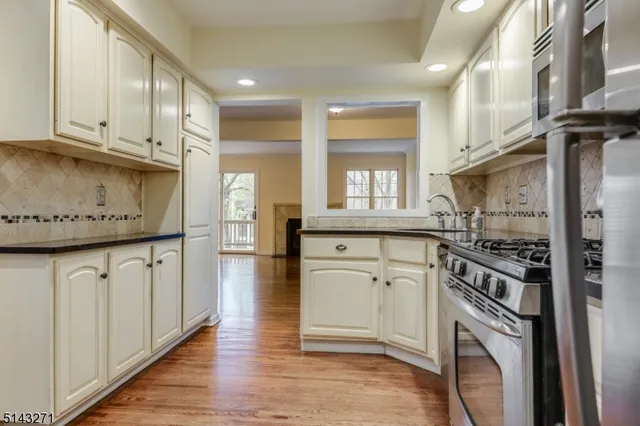 a kitchen with granite countertop a stove top oven sink and cabinets
