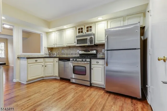 a kitchen with a refrigerator sink and wooden floor
