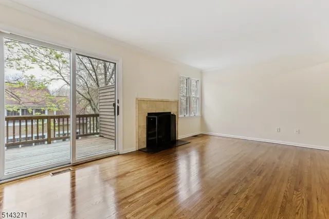 wooden floor fireplace and windows in an empty room