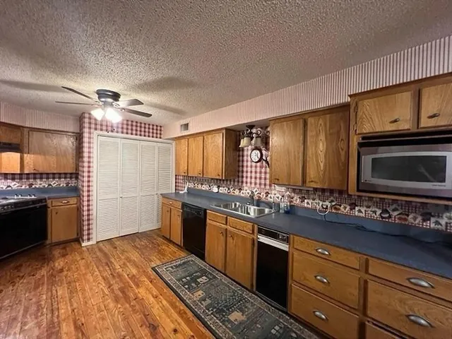 a kitchen with stainless steel appliances granite countertop a stove a sink and a microwave