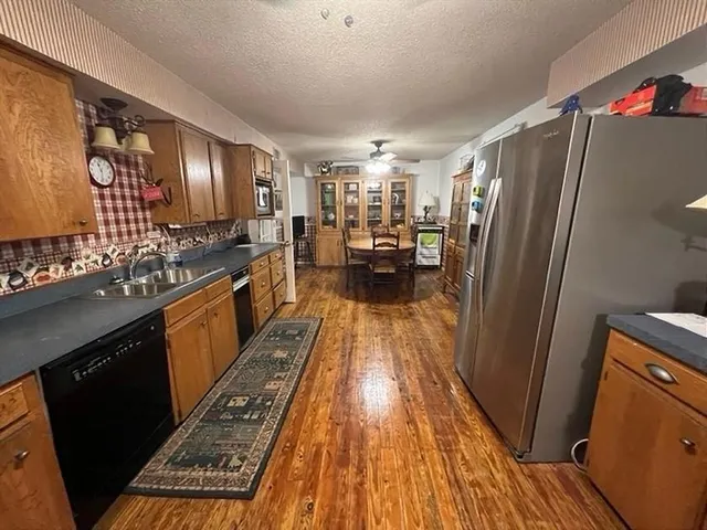 a kitchen with stainless steel appliances granite countertop a refrigerator a stove and a sink