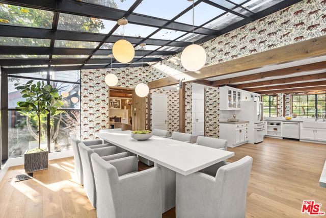 a living room with furniture a flat screen tv and floor to ceiling window