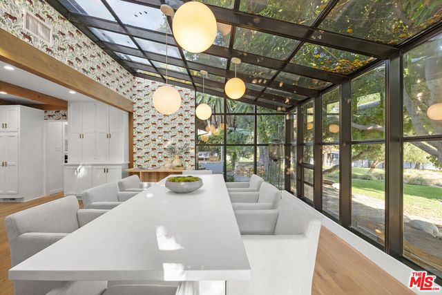 a spacious bathroom with a granite countertop floor to ceiling window and potted plant