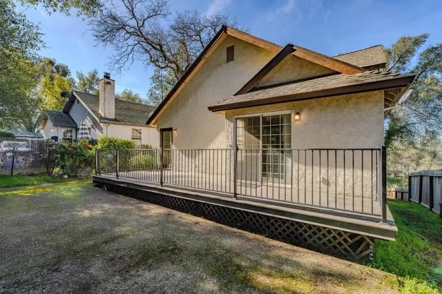 a view of a house with a small yard and wooden fence