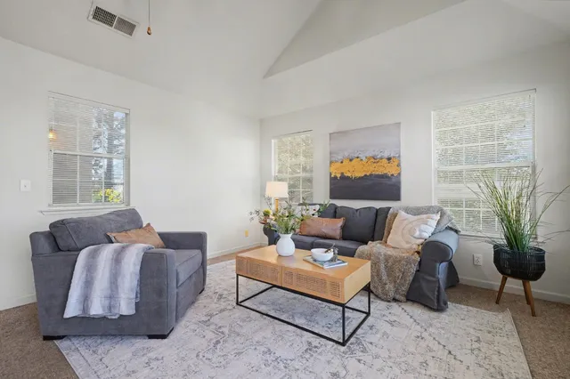 a living room with furniture ceiling fan and a window