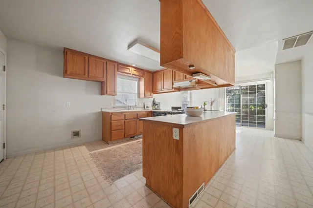 a kitchen with stainless steel appliances granite countertop a stove a sink and a microwave