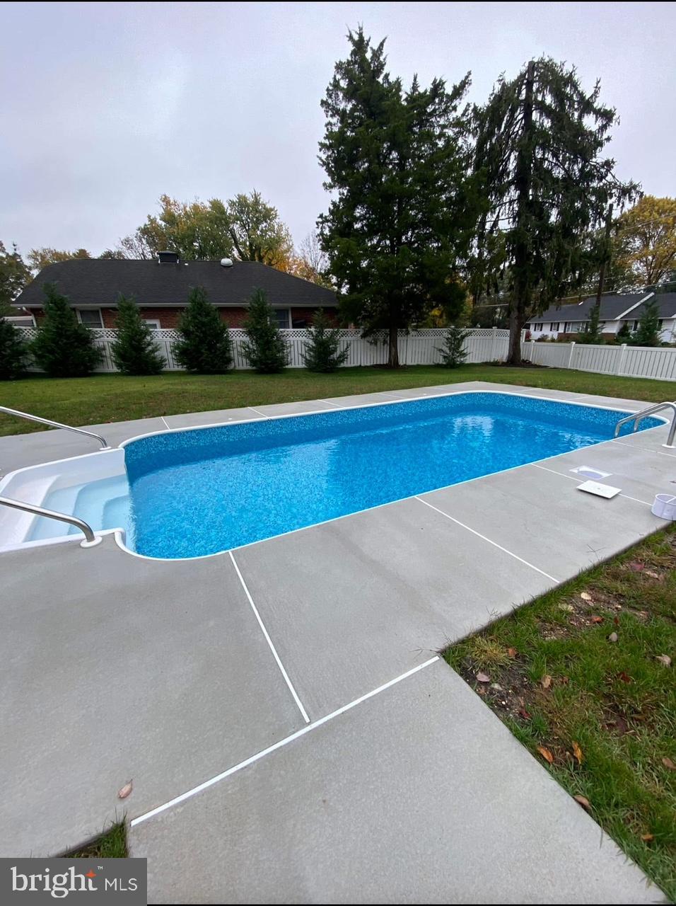 303 Main Street Mantua, NJ 08051 - Photo 5 of 50 a view of swimming pool with large trees and buildings in the background