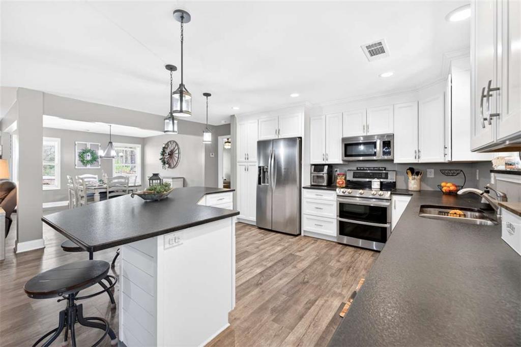 2361 County Line Road Mansfield, GA 30055 - Photo 21 of 57 a kitchen with sink a refrigerator and chairs
