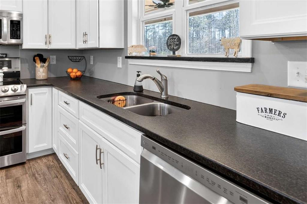 2361 County Line Road Mansfield, GA 30055 - Photo 22 of 57 a kitchen with stainless steel appliances a sink stove and cabinets
