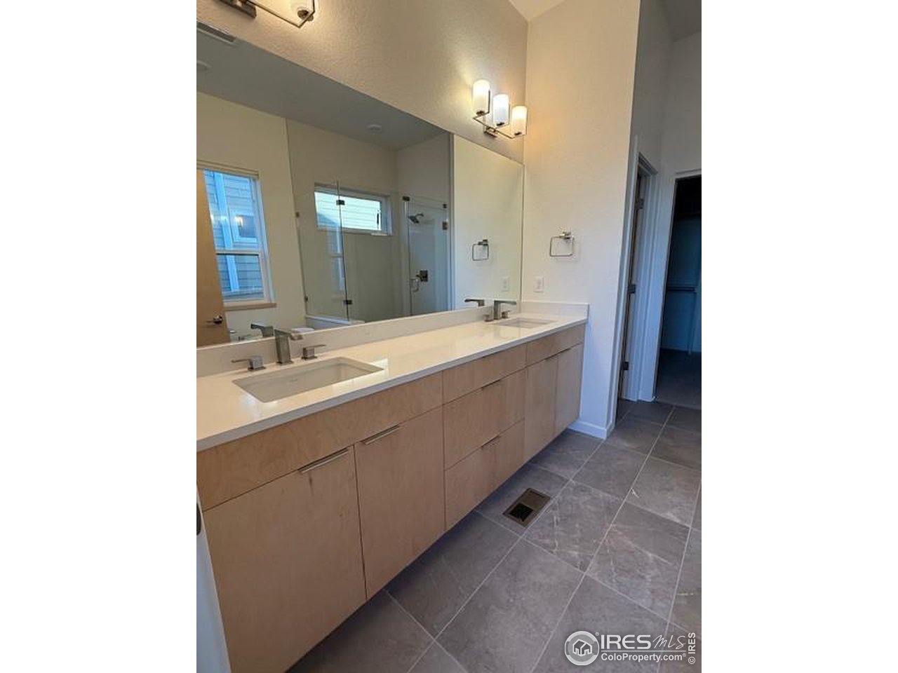 607 Mountain Drive Longmont, CO 80503 - Photo 12 of 18 a spacious bathroom with a double vanity sink and a mirror