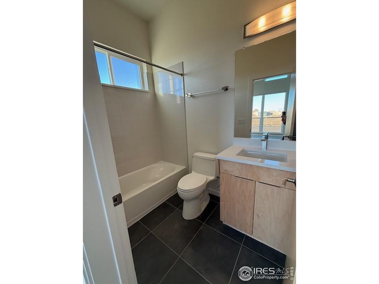 607 Mountain Drive Longmont, CO 80503 - Photo 14 of 18 a bathroom with a granite countertop toilet a sink and a mirror