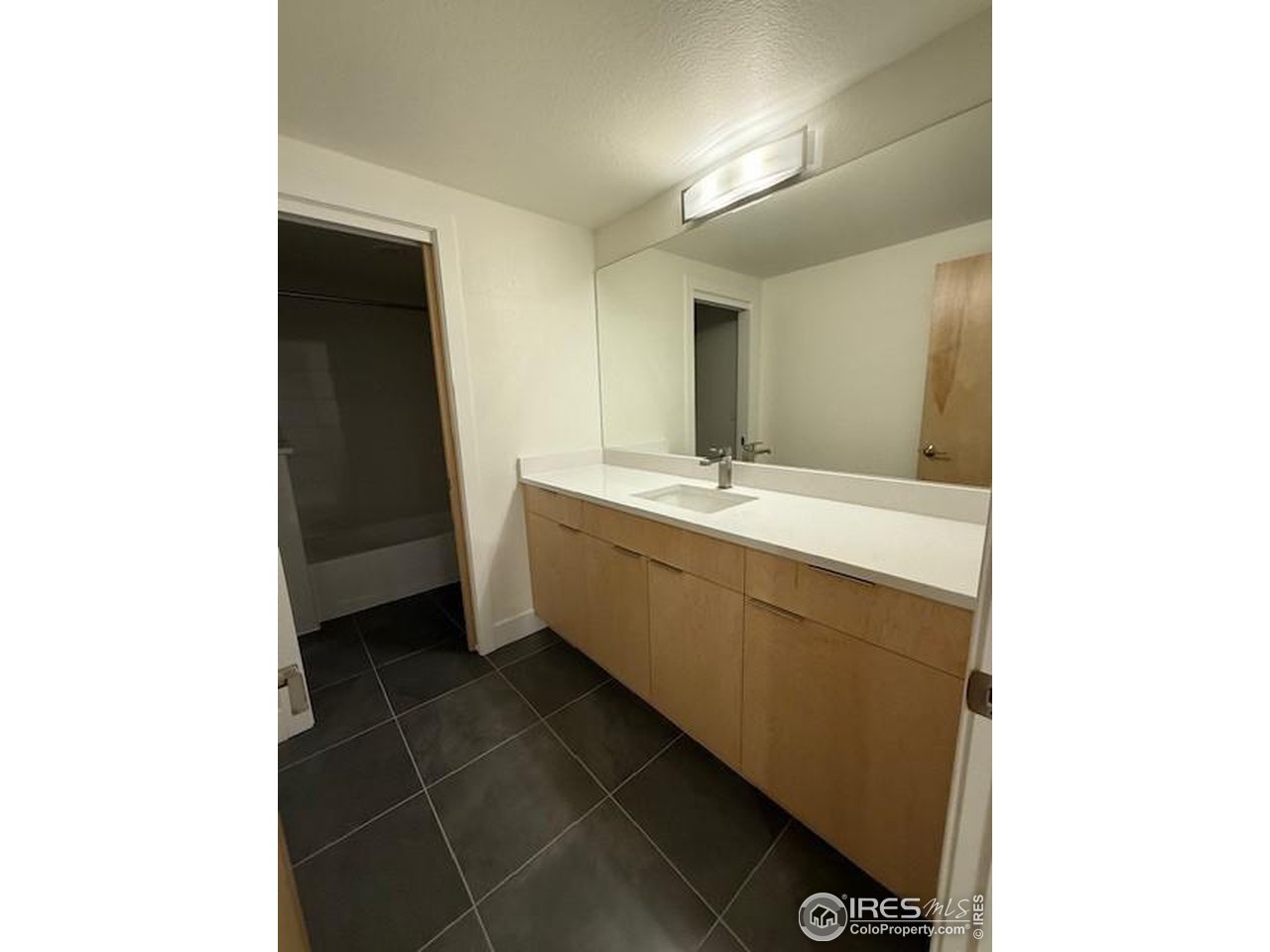 607 Mountain Drive Longmont, CO 80503 - Photo 17 of 18 a bathroom with a sink a toilet and a mirror
