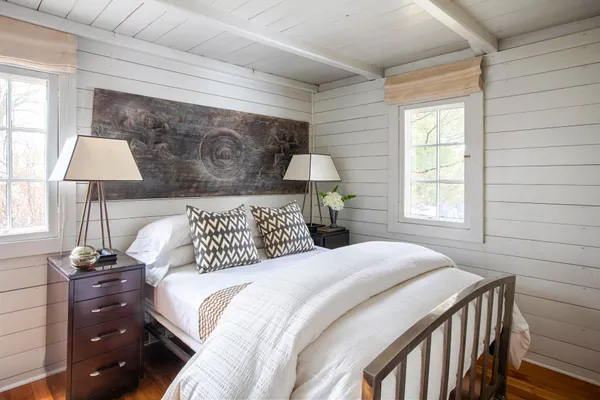a bedroom with a bed and a lamp on dresser