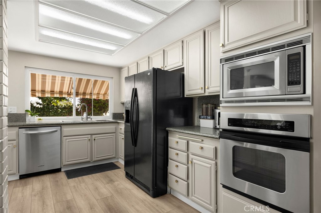 536 Silver Canyon Way Brea, CA 92821 - Photo 9 of 40 a kitchen with white cabinets stainless steel appliances and a window
