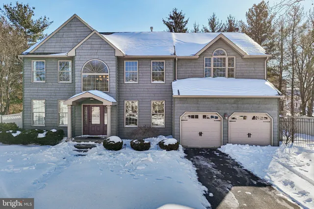 a front view of a house with a yard covered in snow