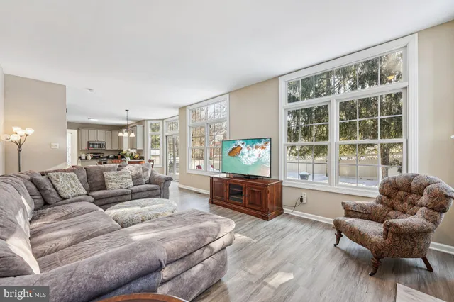 a kitchen with stainless steel appliances granite countertop a refrigerator a stove a sink dishwasher and white cabinets with wooden floor