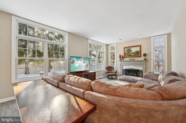 a kitchen with stainless steel appliances granite countertop a stove top oven a sink a refrigerator white cabinets and wooden floor