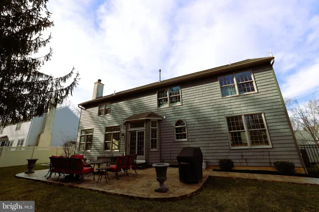 a backyard of a house with fire pit and couches