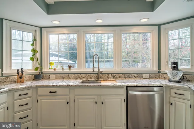 a kitchen with granite countertop sink and window