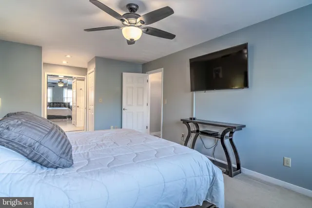 a spacious bedroom with a bed and a flat screen tv