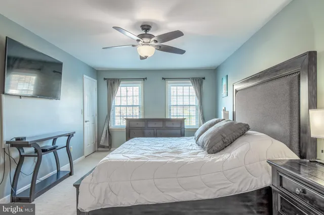 a bedroom with a large bed and a chandelier