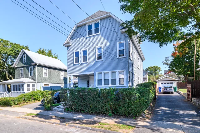 a front view of a house with yard and green space