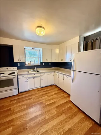 a kitchen with granite countertop a sink stainless steel appliances and cabinets