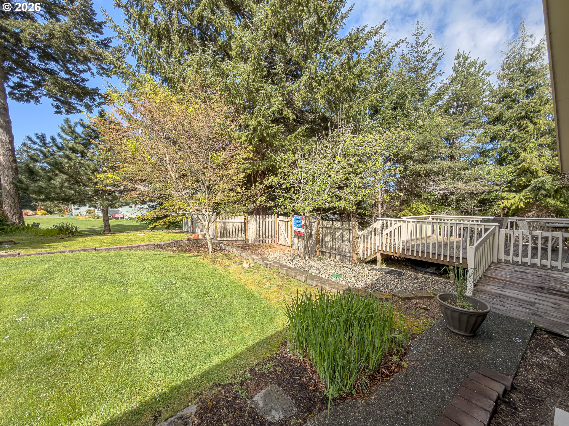 1185 11th Street Southeast Bandon, OR 97411 - Photo 37 of 48 a view of a patio with lawn chairs next to a yard