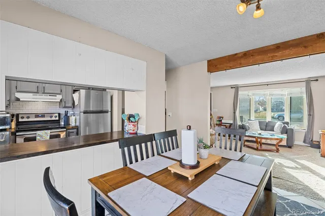 a living room with furniture and a kitchen view