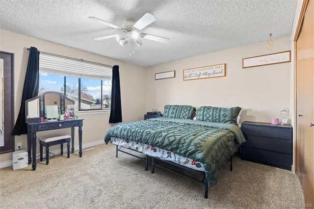 a spacious bedroom with a bed a desk and chair