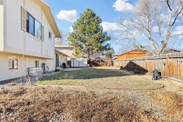 a view of a large white house with a yard and large trees