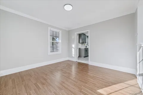 a view of empty room with wooden floor and windows