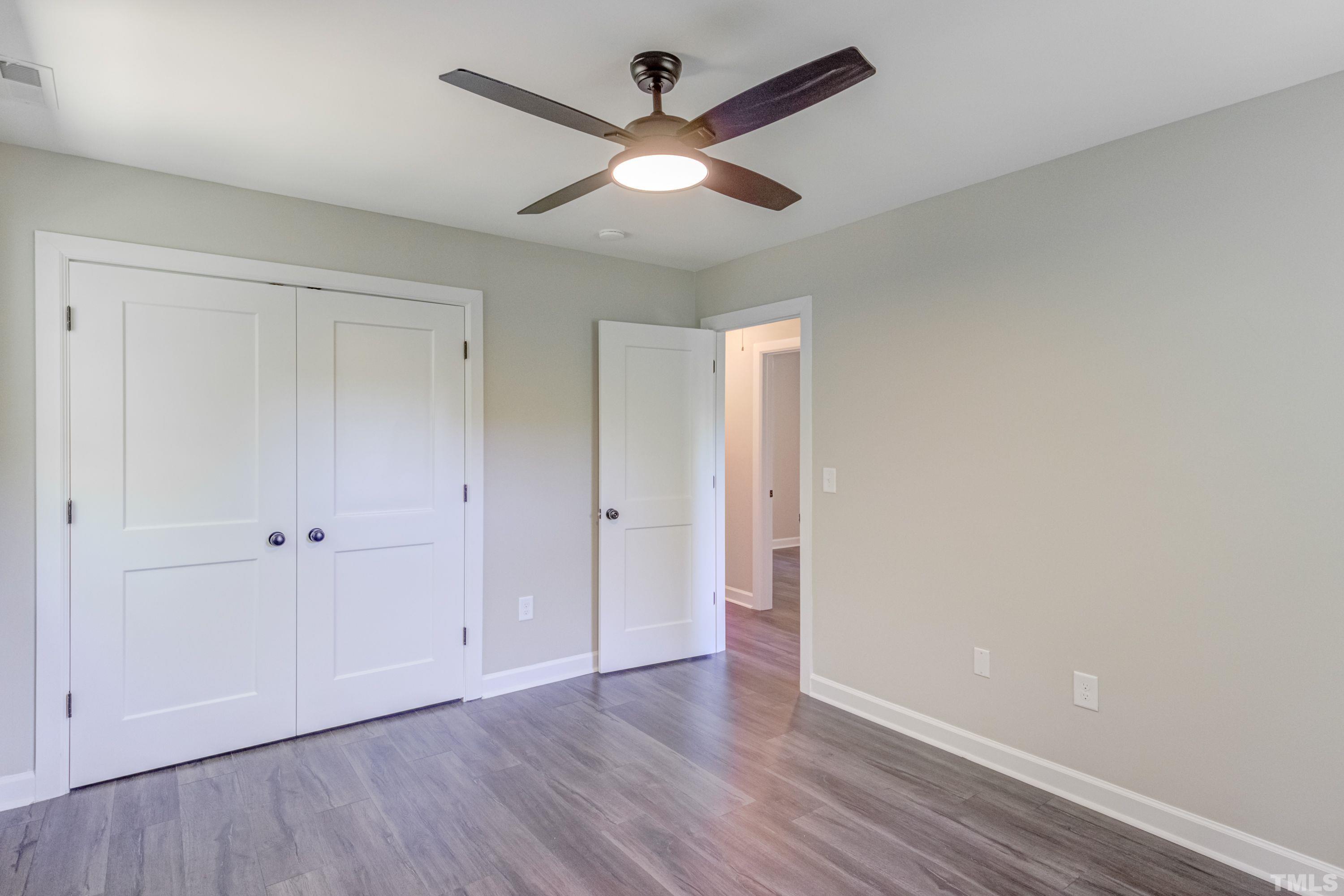 1321 Sedwick Road Durham, NC 27713 - Photo 18 of 27 an empty room with wooden floor and a ceiling fan