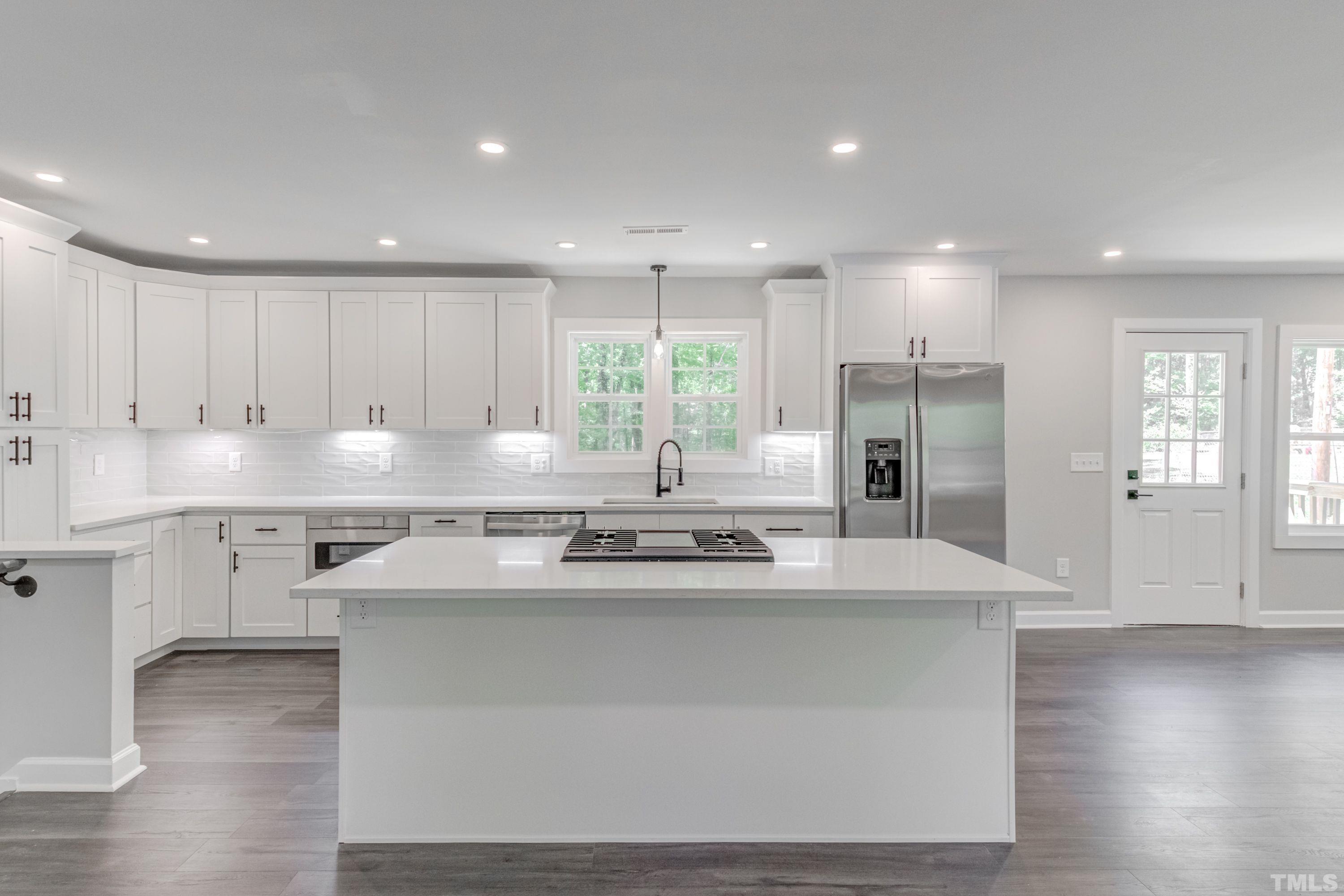1321 Sedwick Road Durham, NC 27713 - Photo 9 of 27 a kitchen with stainless steel appliances granite countertop a sink stove and refrigerator