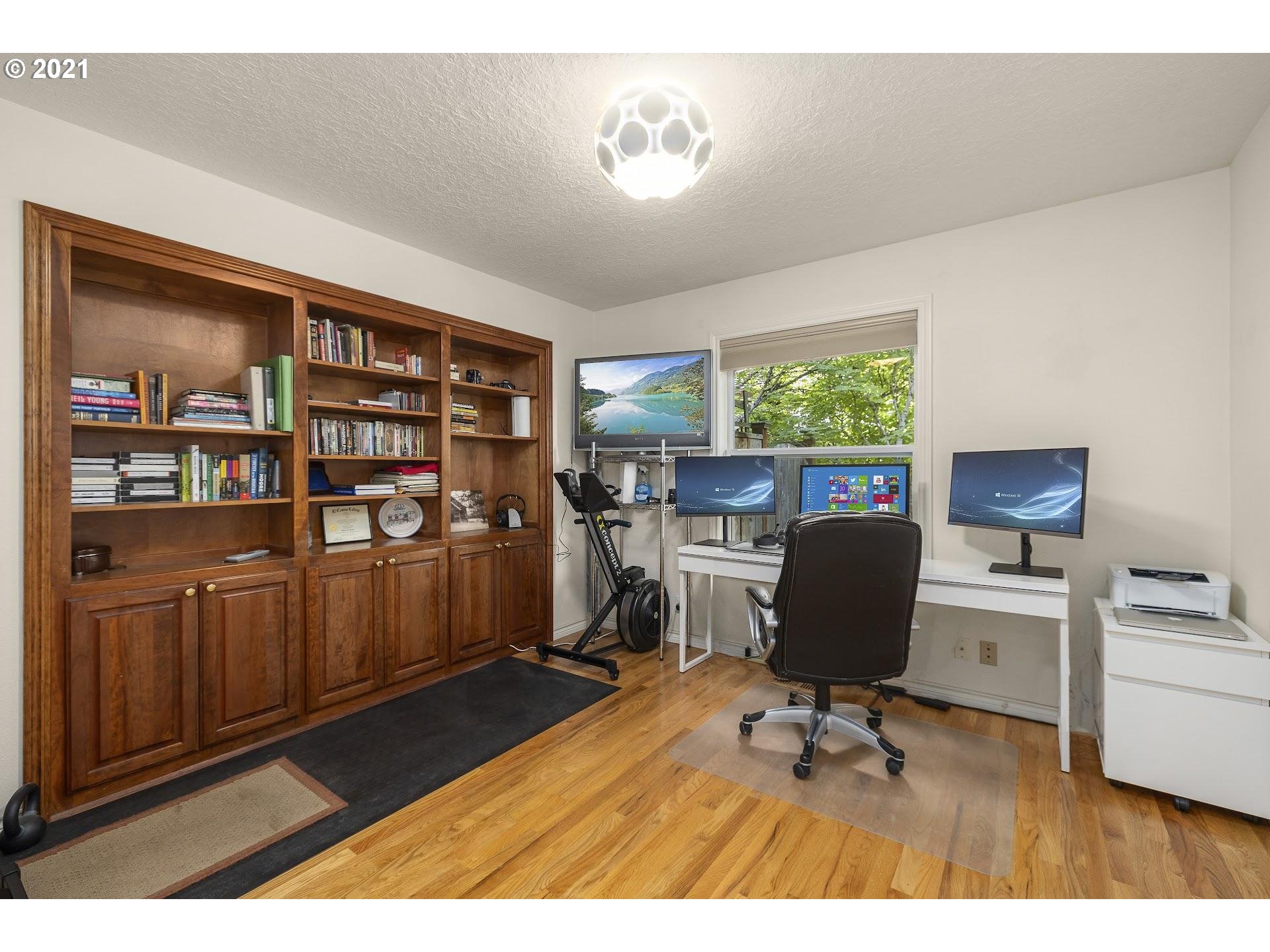 3916 Southwest Shattuck Road Portland, OR 97221 - Photo 13 of 28 a view of a workspace with furniture and a bookshelf