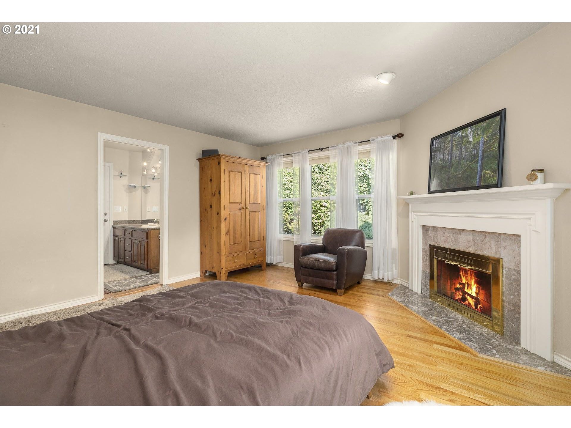 3916 Southwest Shattuck Road Portland, OR 97221 - Photo 16 of 28 a bedroom with a bed and a fireplace