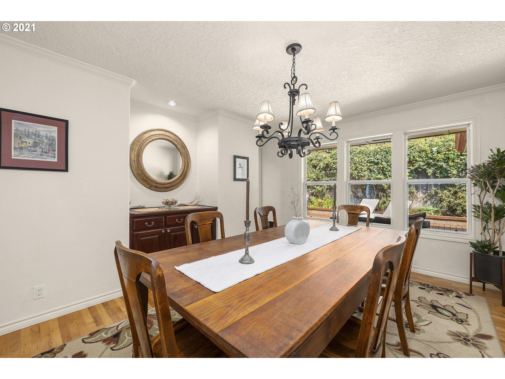 3916 Southwest Shattuck Road Portland, OR 97221 - Photo 9 of 28 a view of a dining room with furniture a chandelier and wooden floor