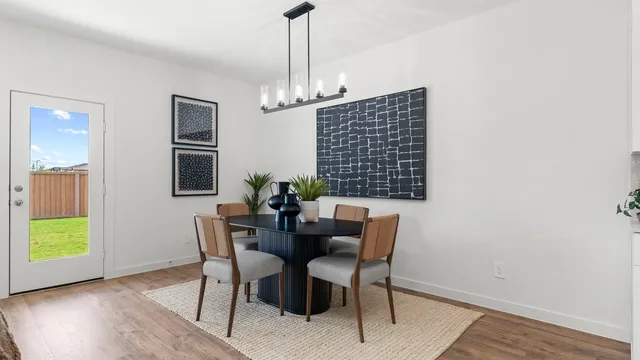 a dining room with furniture a chandelier and wooden floor