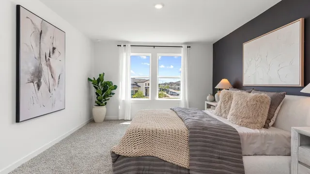 a bedroom with a large bed and a potted plant